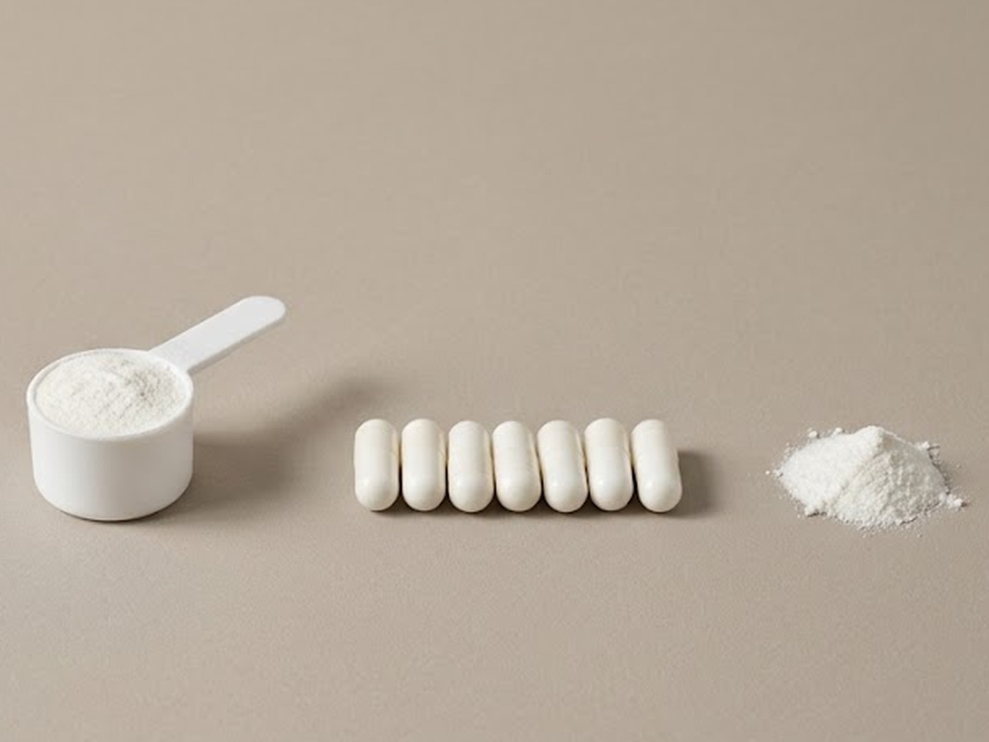 Illustration: a white scoop of fine white powder, seven white capsules in a row and a small pile of white powder, set on plain taupe paper