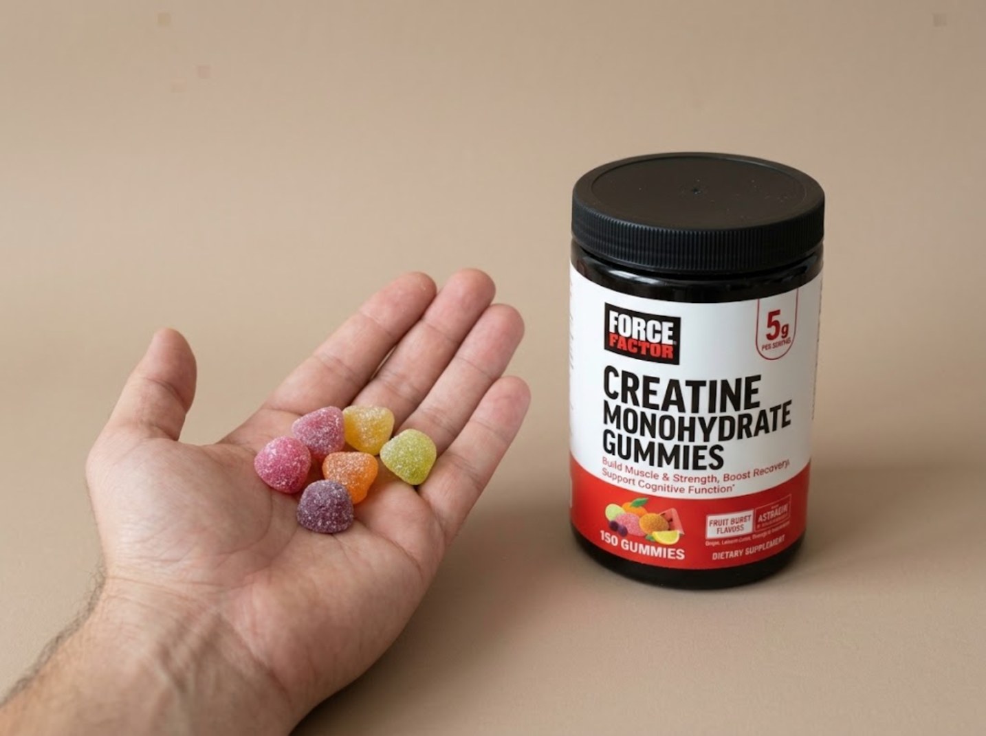 Five Force Factor gummies in an open palm next to the jar